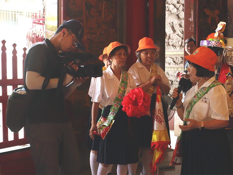 公視攝影師在廟宇拍攝社區長輩導覽